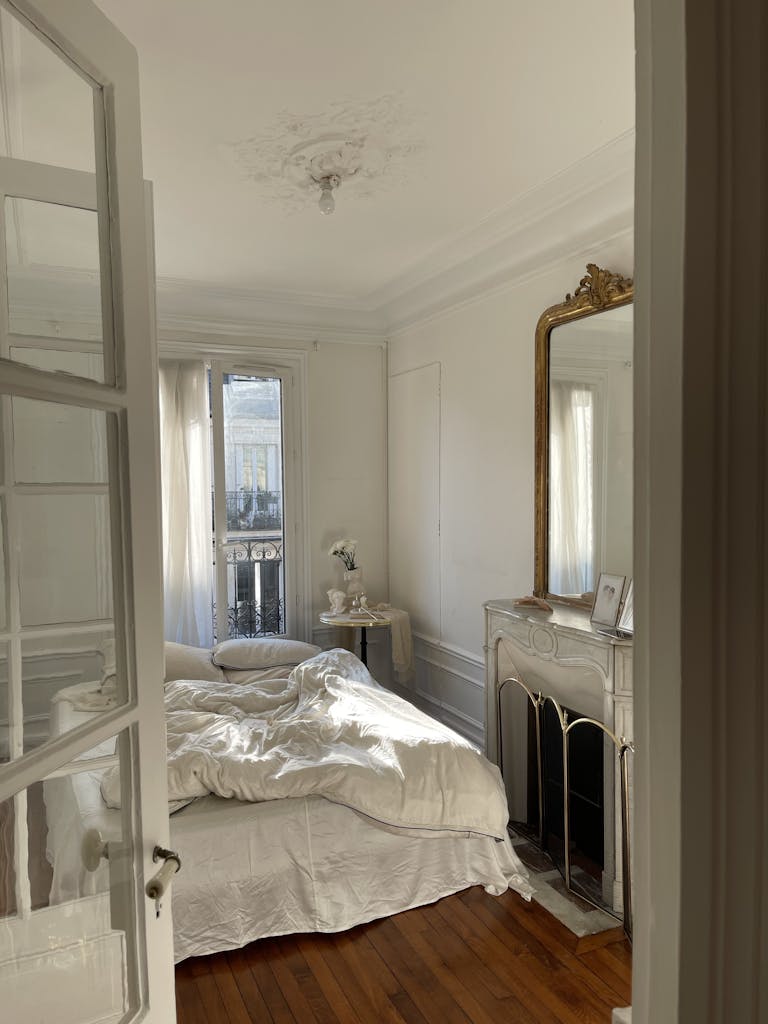 Elegant French-style bedroom bathed in natural light, featuring vintage decor.