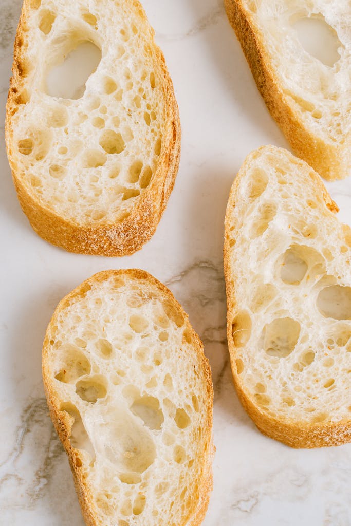 Top view of artisan bread slices on a marble surface. Perfect for culinary themes.