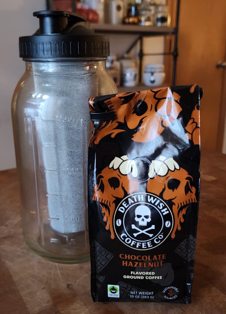 Bag of ground coffee and a cold brew making jug