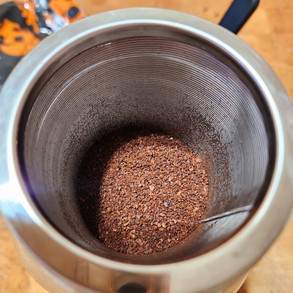 coffee grounds in metal strainer