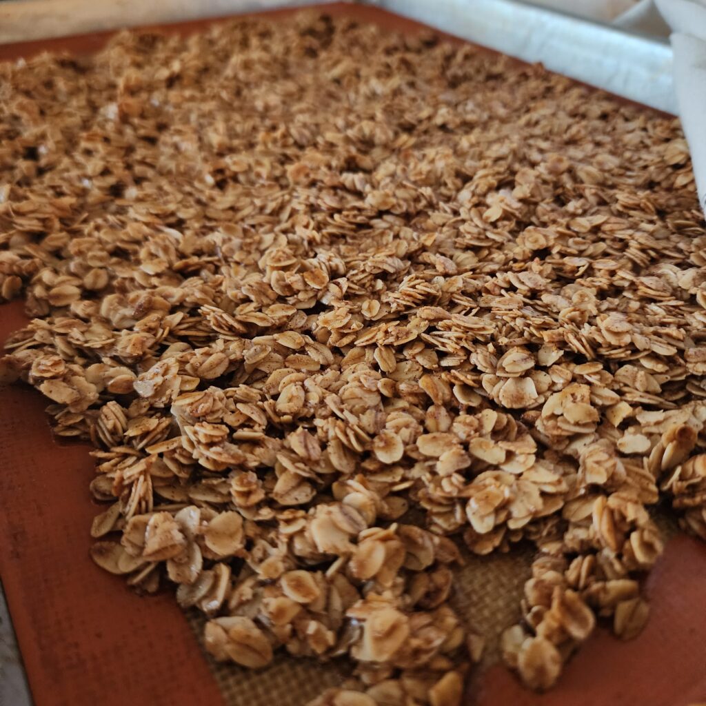 Homemade granola evenly spread on a sheet pan