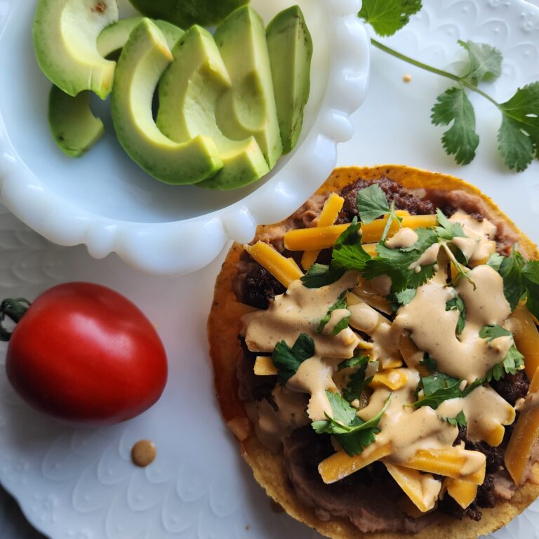 The Best Chipotle sauce drizzled on a tostada with cheese and avacado