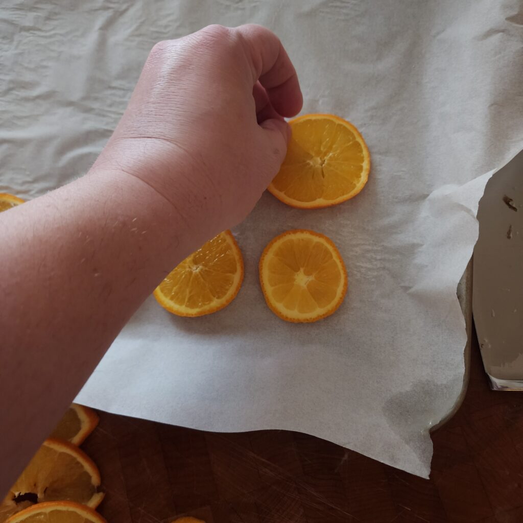 Placing orange slices on baking sheet 