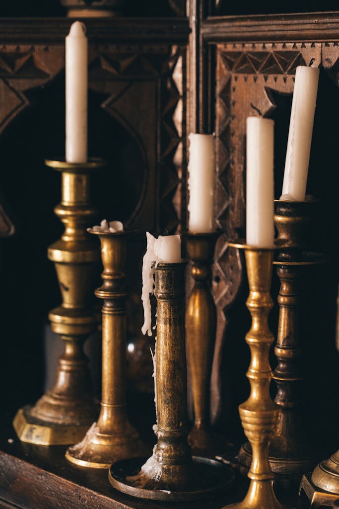 Ornate vintage brass candlesticks with melting wax candles in an elegant arrangement.