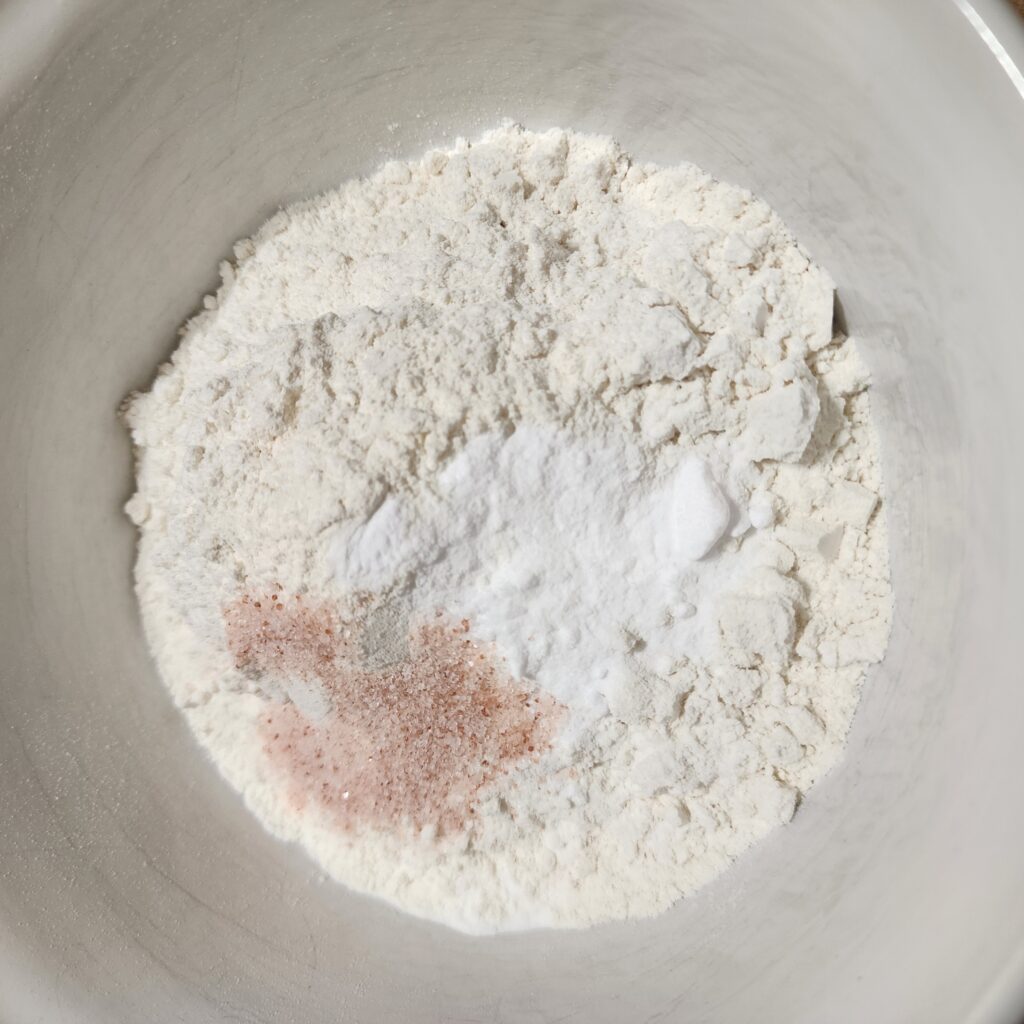 Flour, baking soda, and salt in a white mixing bowl