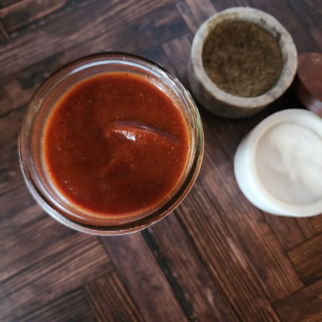 Made from  scratch  BBQ Sauce in a jar with salt a d pepper cellars