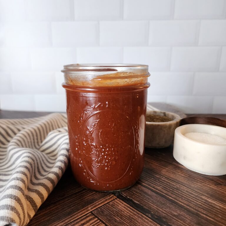 Made from scratch sweet and zesty bbq sauce on a wooden table in a Mason jar