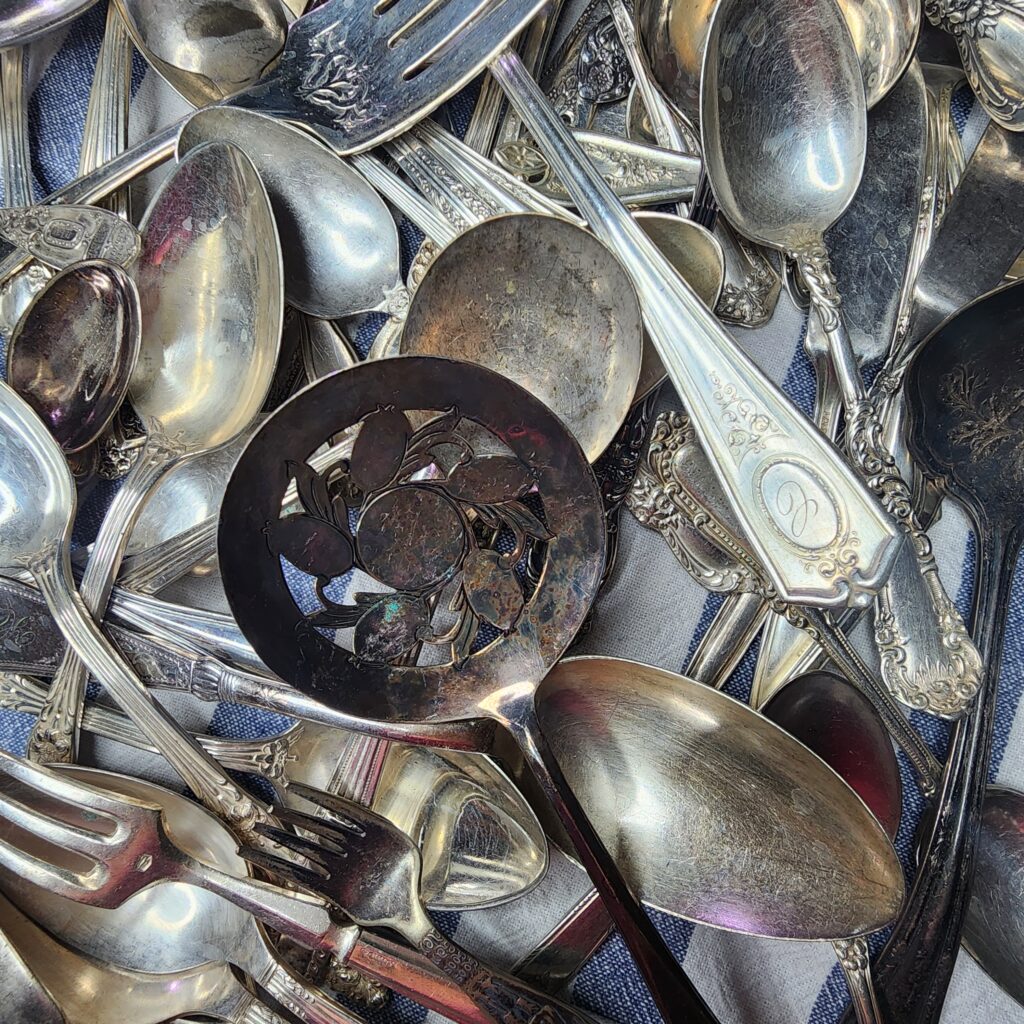 Vintage Tarnished Silverware laying on a blue and white tea towel