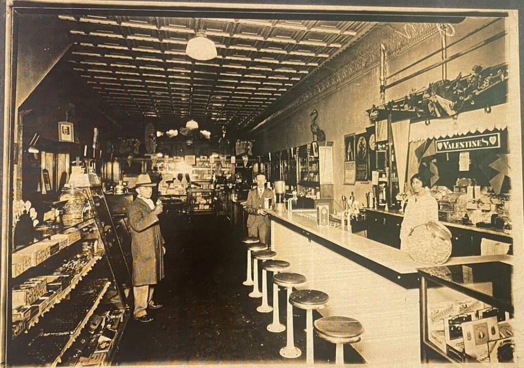 A picture of an old drug store interior with white pressed tin ceilings