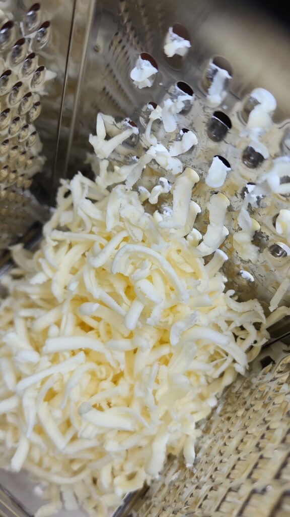 Cold butter is being grated with a cheese grater