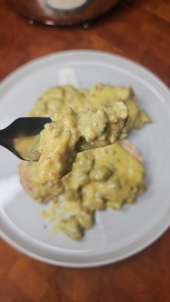 Sourdough Buttermilk Biscuits with Creamy Tumeric Sausage Gravy served on a white plate 