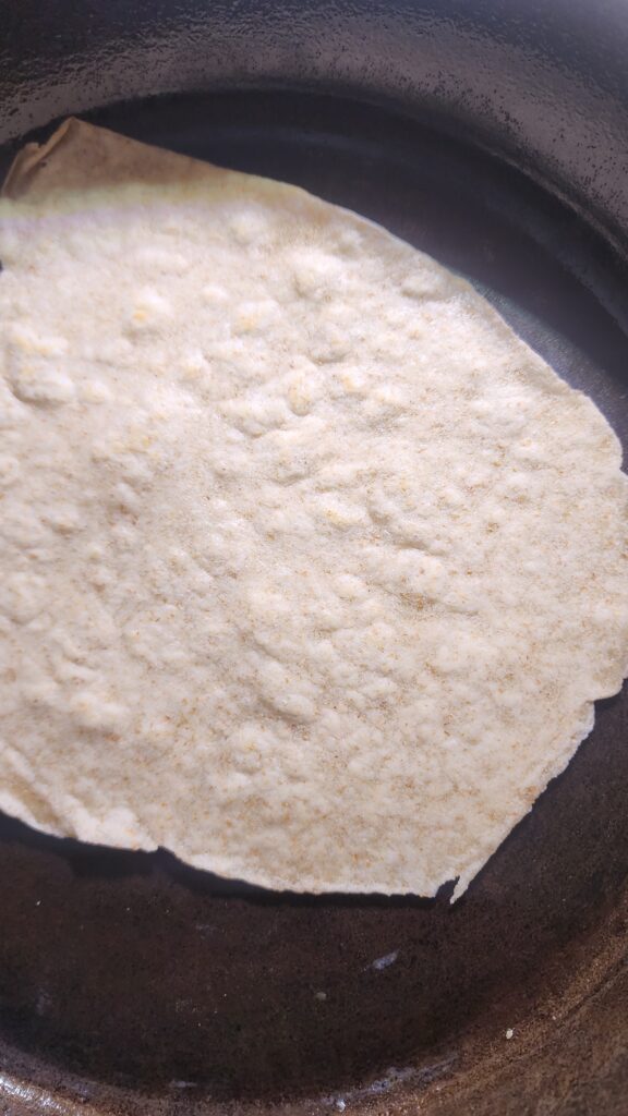 Cooking Sourdough Discard tortillas in a cast iron skillet 