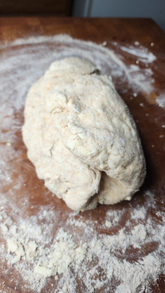 Sourdough Buttermilk Biscuit dough is being shaped to create flaky laters