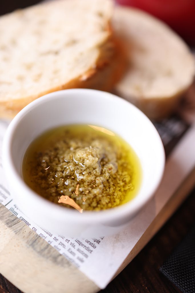 Close-up of artisan bread slices with a bowl of olive oil and herb dip.