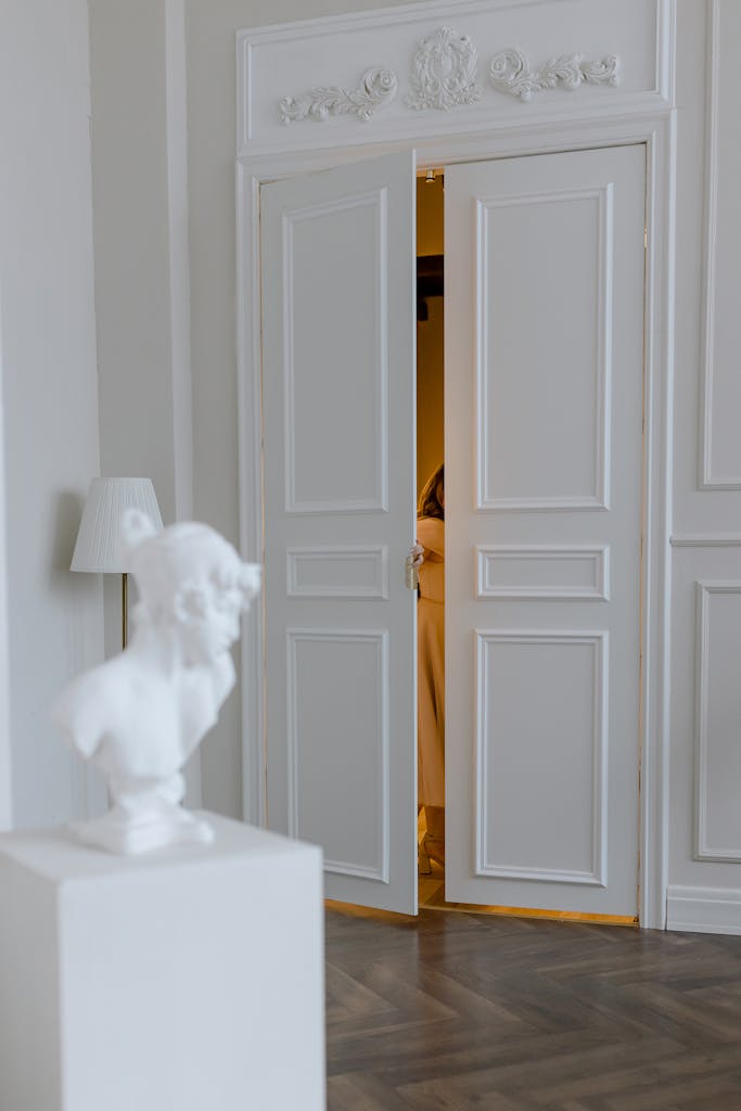 Inside view of a classic white doorway and statue, exuding elegance and timeless style.