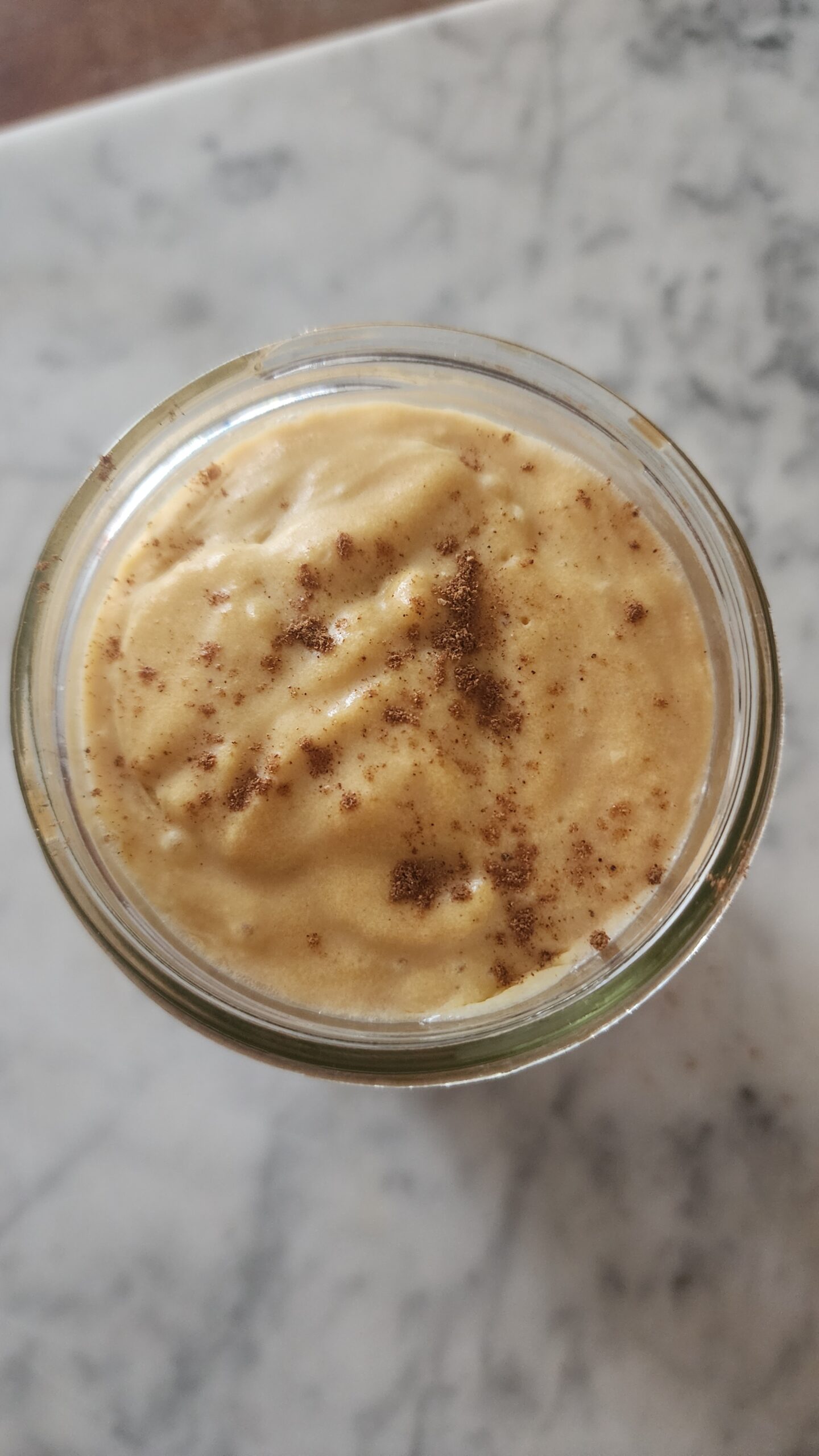 A cozy iced chai tea latte is topped with creamy pumpkin cold foam creating the perfect fall drink.