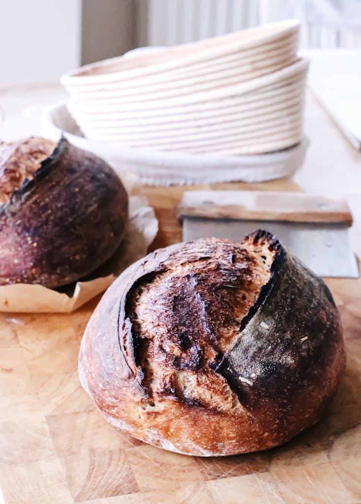 Freshly baked artisanal sourdough loaves on a kitchen table, showcasing their rustic crust.