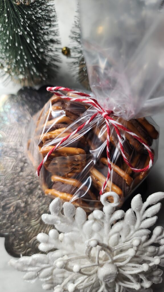 Sweet and Salty Christmas Candy in a cellophane bag tied with festive red and white bakers twine creating a beautiful DIY edible gift idea for the holidays. 