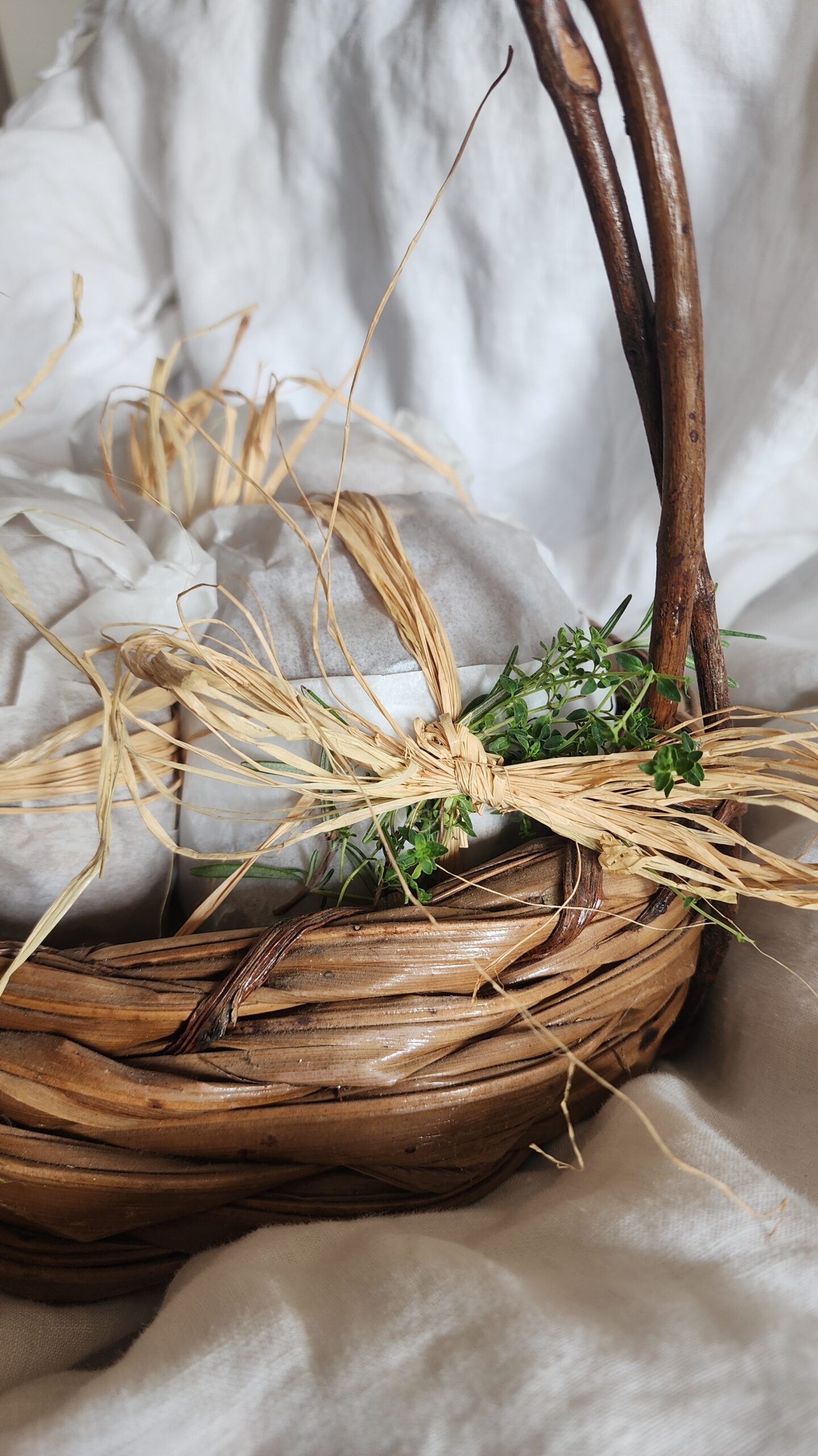 A thrifted basket filled with fresh sourdough mini loaves ready to gift for the holidays.