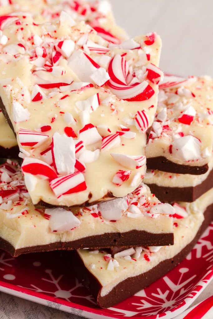 Pieces of holiday peppermint bark on a festive red plate, ready to eat and gift to friends and family