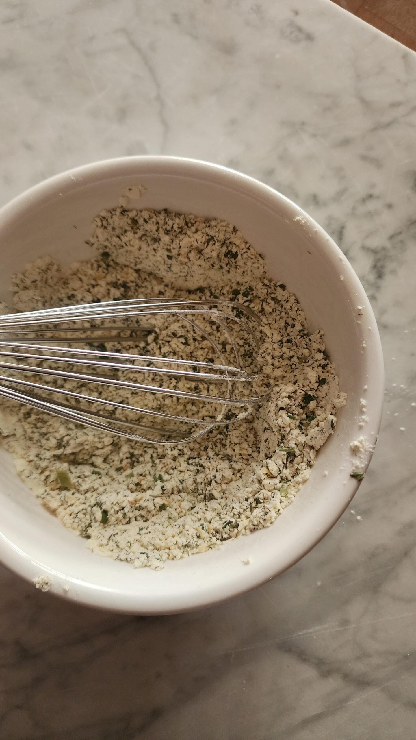 Homemade Ranch Seasoning Mix in a white bowl on a marble surface.
