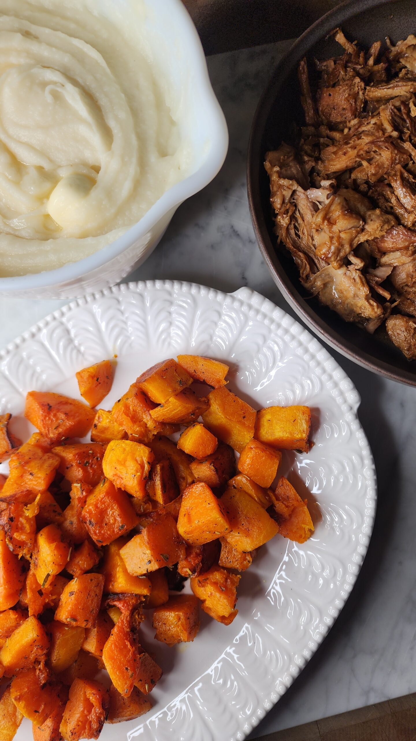 A cozy display of roasted butternut squash with brown butter, Mississippi Pot Roast, and creamy mashed potatoes.