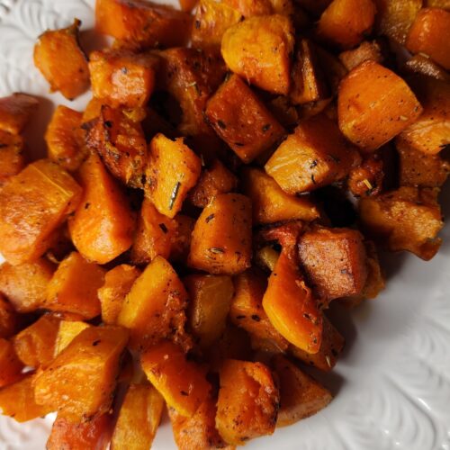 Freshly roasted butternut squash with browned butter on a white platter and ready to serve as the ultimate cozy side dish recipe.