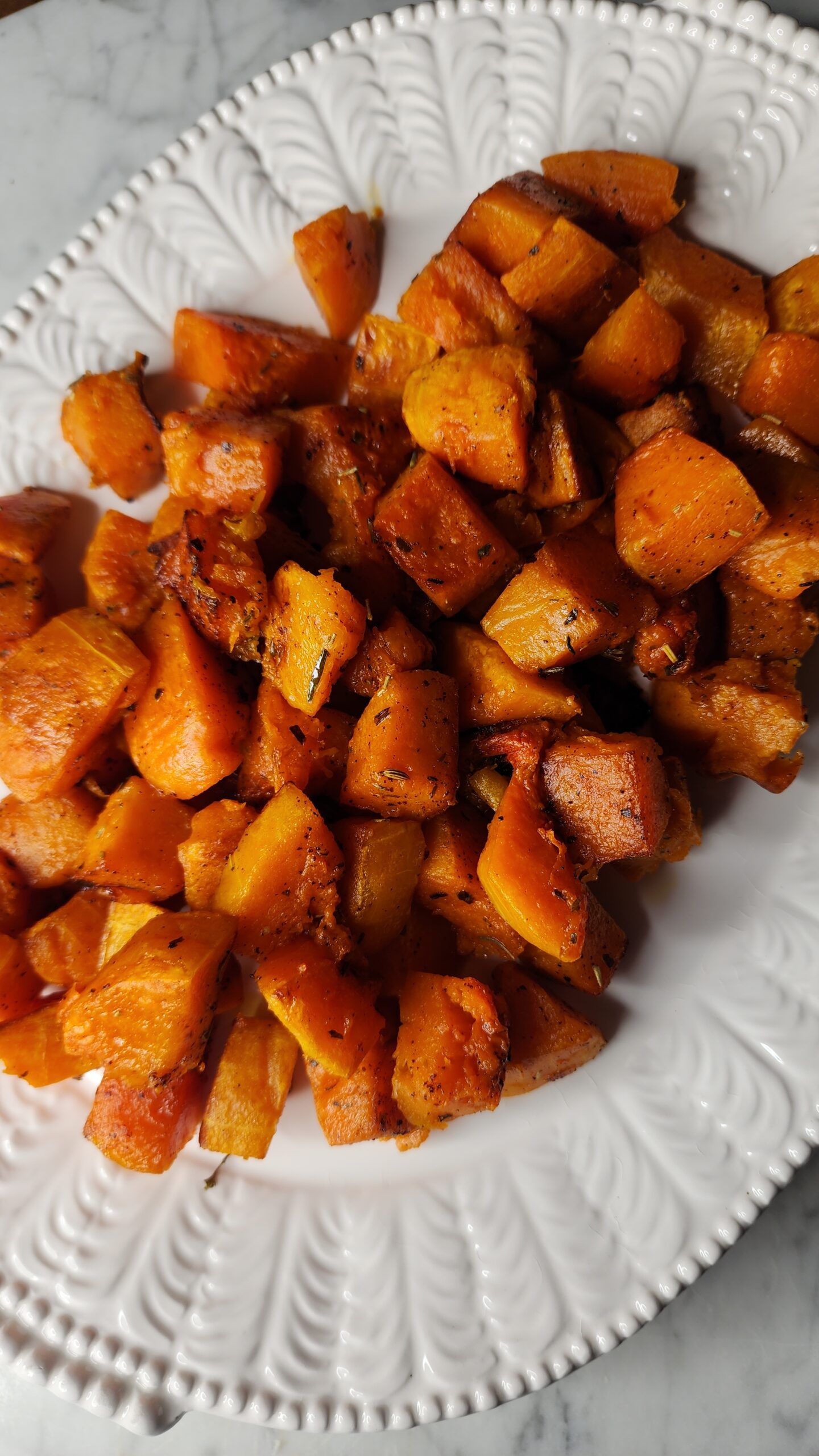 Freshly roasted butternut squash with browned butter on a white platter and ready to serve as the ultimate cozy side dish recipe.