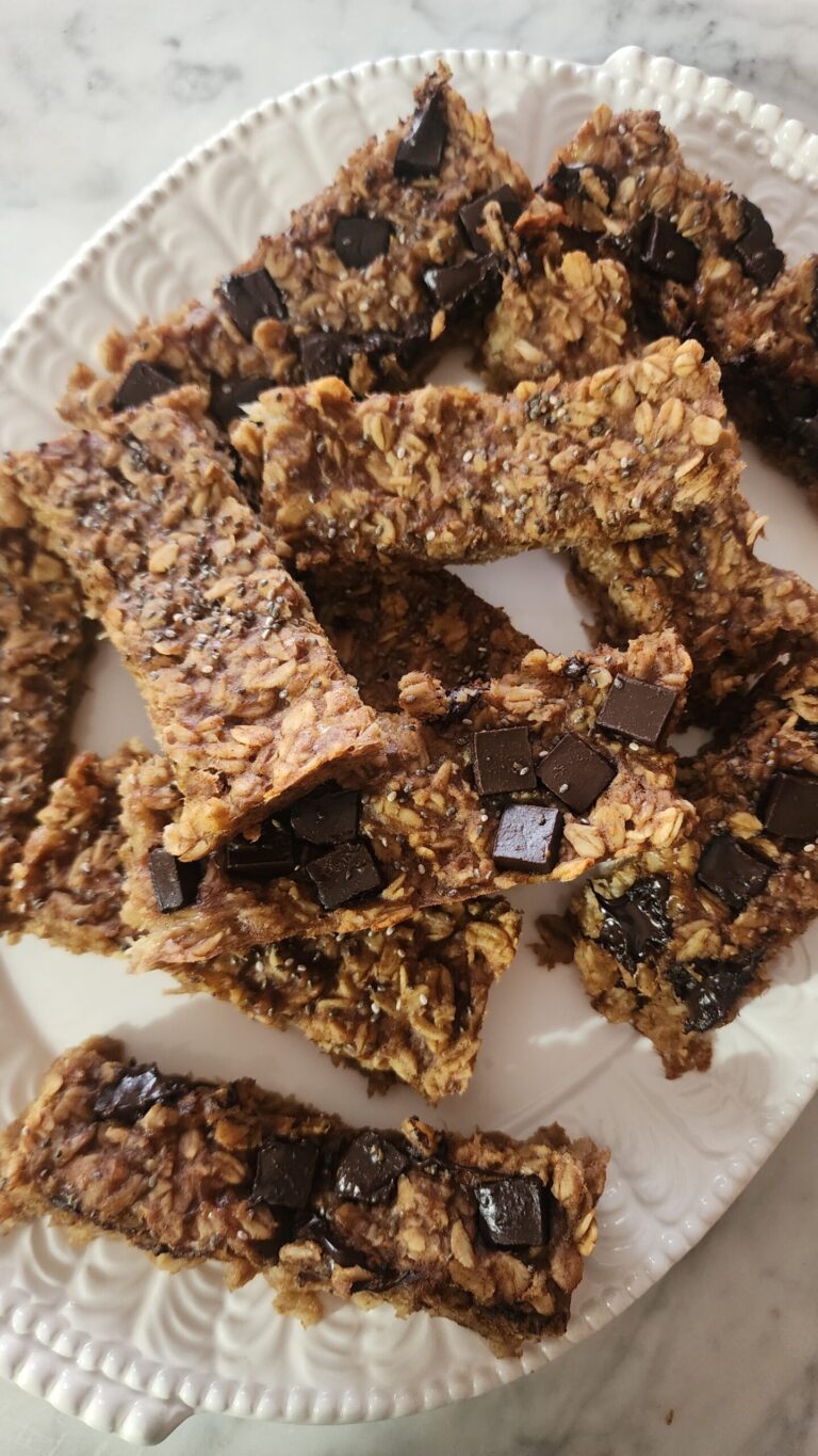 Peanut Butter Banana Oat Bars are stacked on a white platter ready to enjoy as an easy post workout snack.