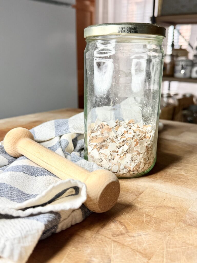A jar of crushed egg shells in a glass jar.