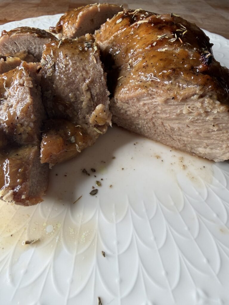 Savory and sweet maple Dijon pork tenderloin medallions on a white plate.
