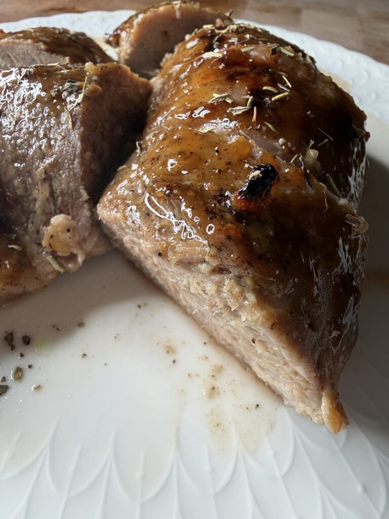 Savory and sweet maple Dijon pork tenderloin medallions on a white plate.