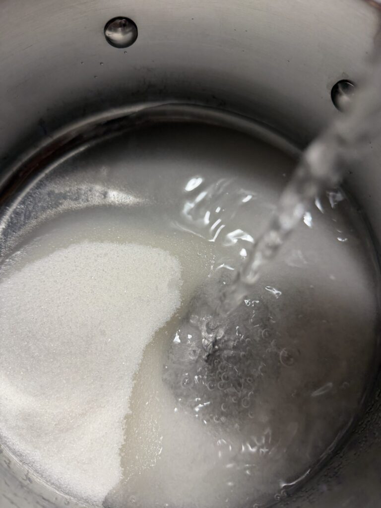 Sugar and water in a saucepan ready to make into simple syrup. 
