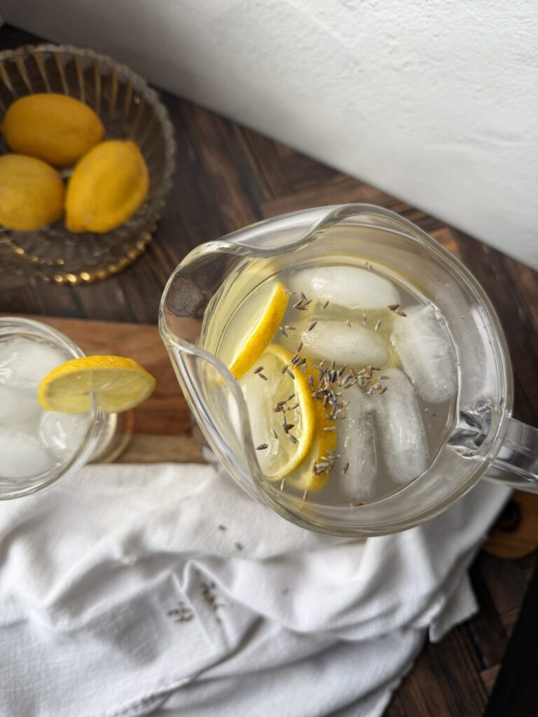 A pitcher of fresh kefir lavender lemonade with fresh lemons. 