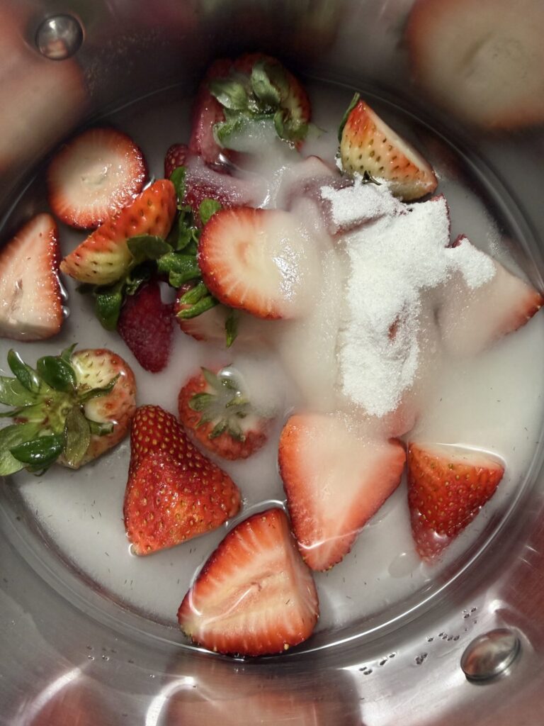 Ingredients for strawberry simple syrup in a sauce pan ready to cook. 