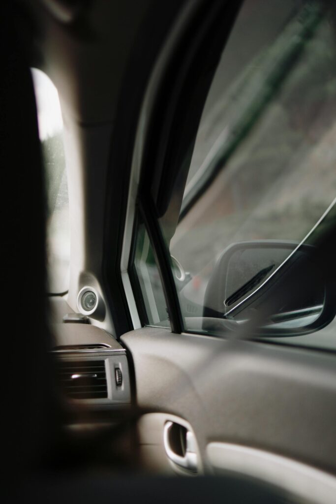 Interior car view focusing on the side window and rearview mirror.