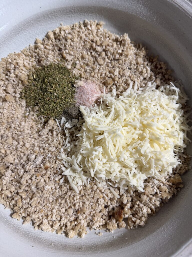 Herbs and spices in a bowl with homemade sourdough breadcrumbs ready to make chicken parmesan. 