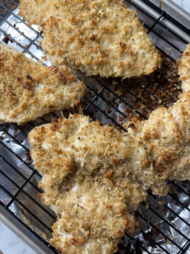Baked chicken with sourdough breadcrumbs on a wire rack. 