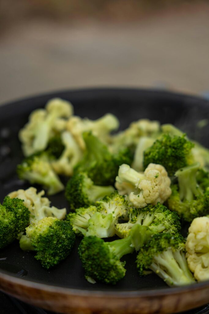 Close-up of fresh steamed broccoli florets in a pan, perfect for healthy eating themes.