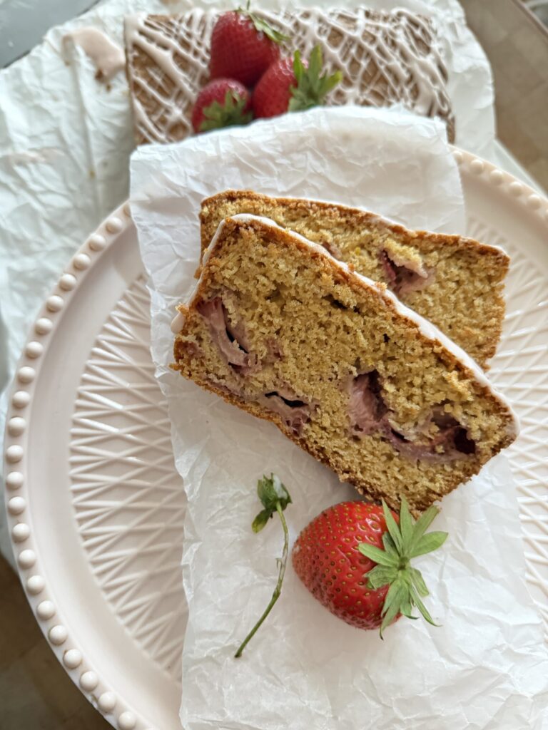 Two slices of sourdough strawberry bread on a pink cake stand. 