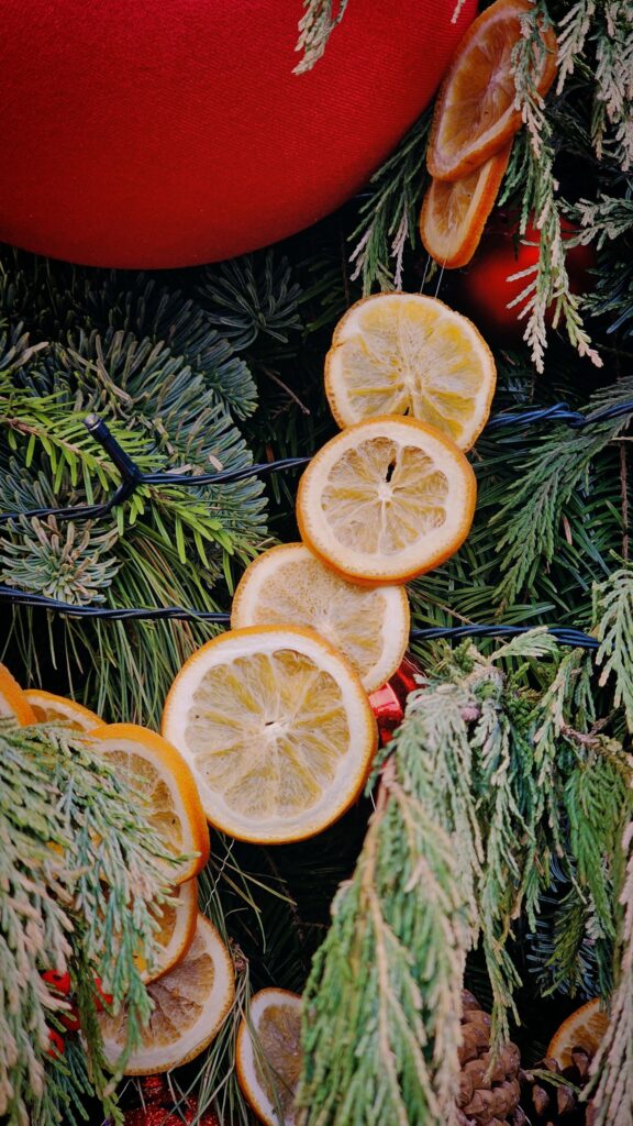 Colorful Christmas decoration featuring dried orange slices and fir branches creating a festive mood.