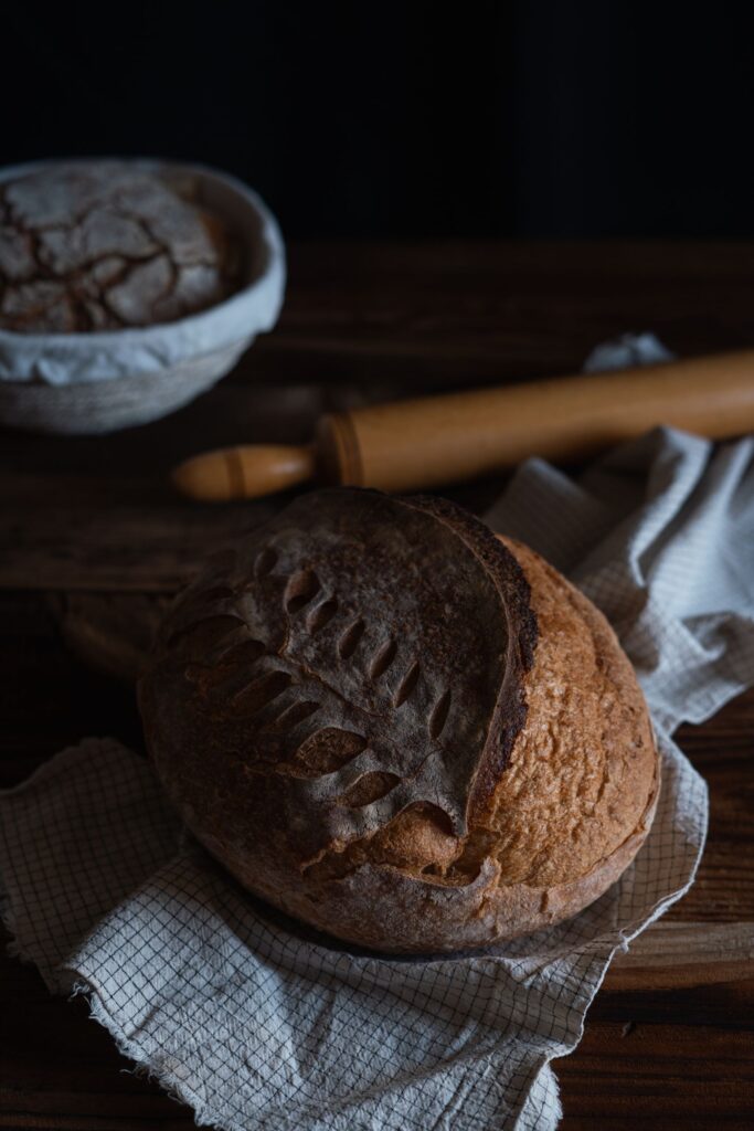 Dark and moody artisan bread with rustic texture, perfect for food styling.