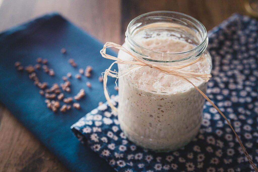 Sourdough starter in a glass jar with twine.