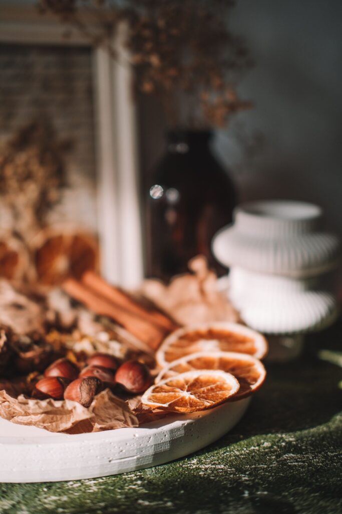 Warm autumnal scene with dried oranges and rustic decor in soft lighting.