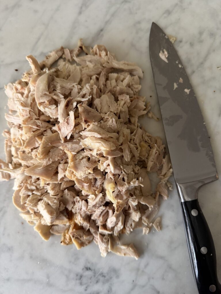 Chopped chicken on a marble surface.
