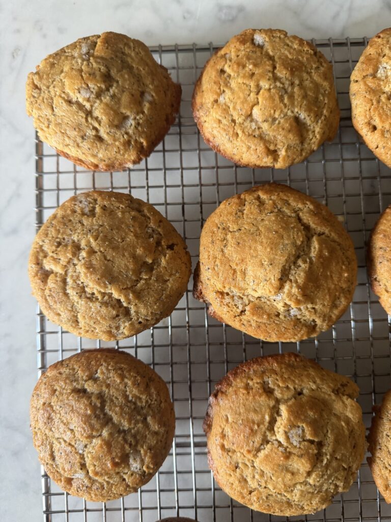 Sourdough lemon poppy seed muffins on a cooling rack.