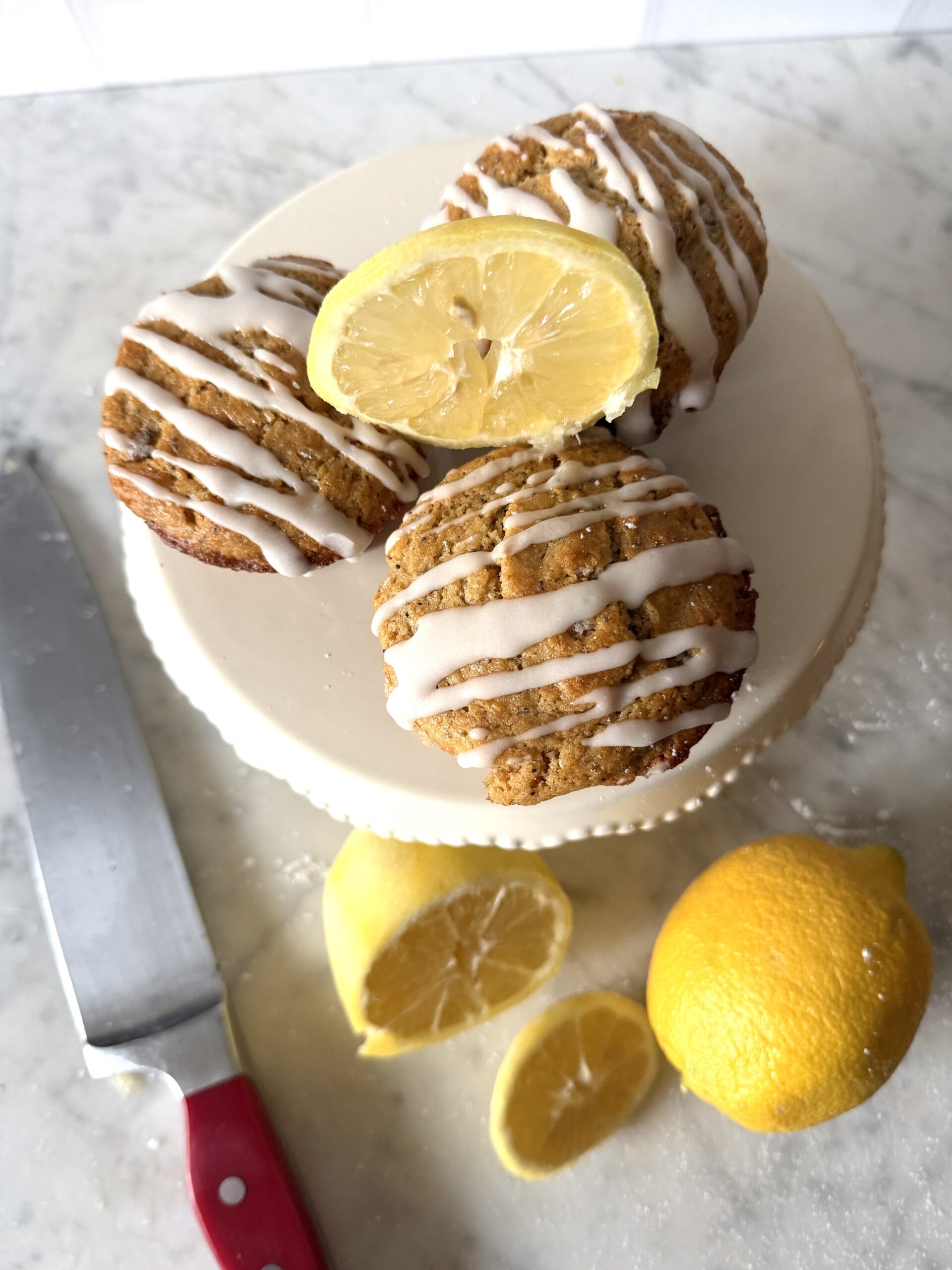Delicious sourdough discard lemon poppy seed muffins with sliced lemons on a mini cake stand.