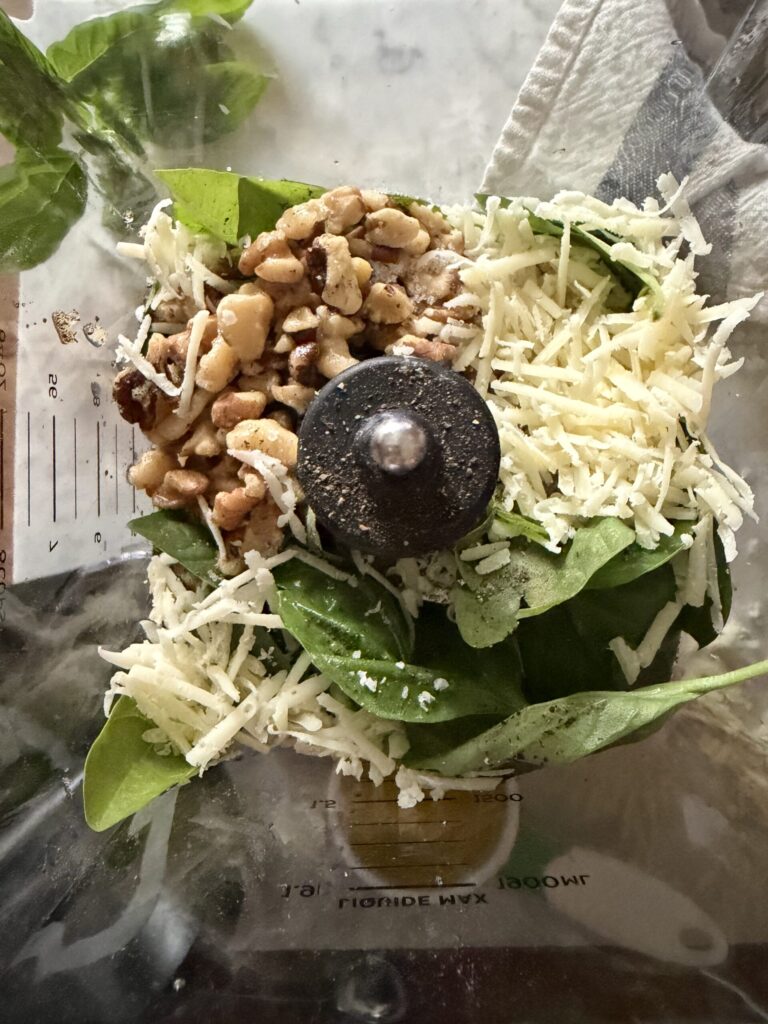 Ingredients for homemade walnut basil pesto in a blender. 