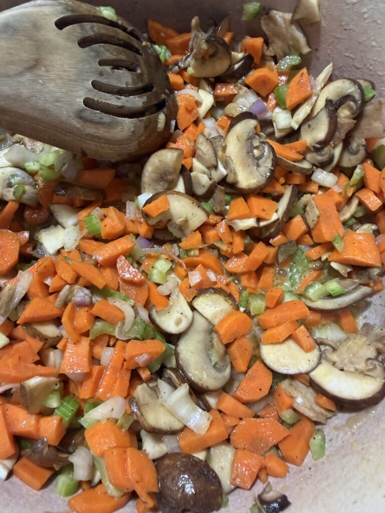 Carrots, mushrooms, garlic, and shallots are sautéed in a skillet