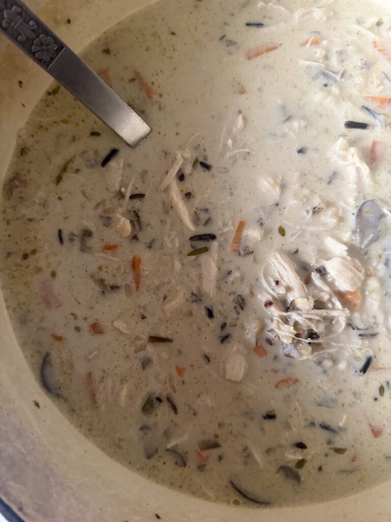 Cream and shredded chicken are added to create a creamy wild rice and rotisserie chicken soup